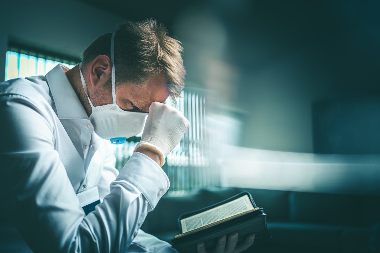 Doctor praying over a bible